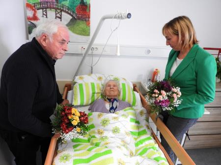slika_Mariji Mežek sta za 104 rojstni dan čestitala in izročila šopek rož direktorica Doma Taber  Martina Martinčič in župan Cerkelj Franc Čebulj 